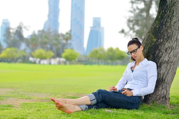 Hermosa joven con tableta en el parque — Foto de Stock