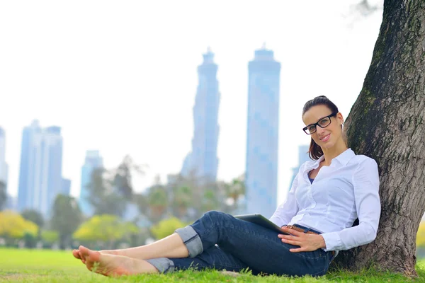 Hermosa joven con tableta en el parque — Foto de Stock