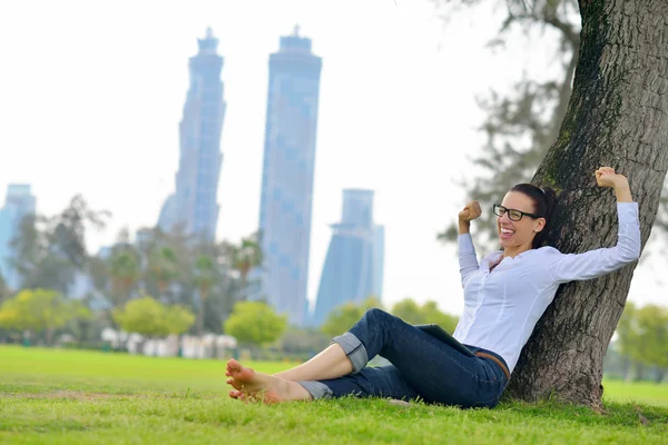 Bella giovane donna con tablet nel parco — Foto Stock