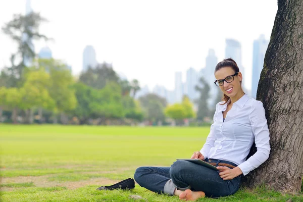 Красива молода жінка з планшетом в парку — стокове фото
