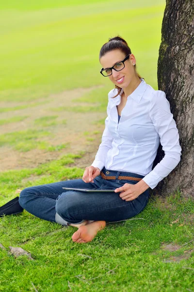 Bella giovane donna con tablet nel parco — Foto Stock