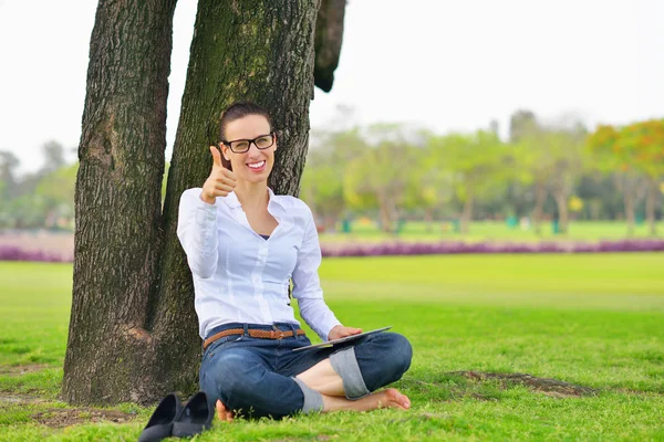 Bella giovane donna con tablet nel parco — Foto Stock