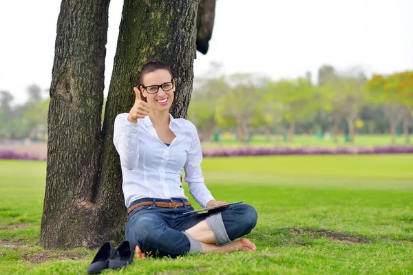 Bella giovane donna con tablet nel parco — Foto Stock