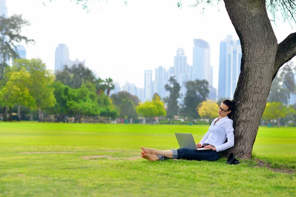 Женщина с ноутбуком в парке — стоковое фото