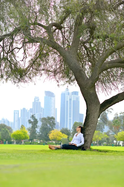 Vrouw met laptop in park — Stockfoto