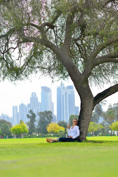 Vrouw met laptop in park — Stockfoto