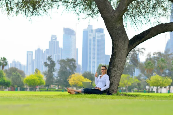 Donna con computer portatile nel parco — Foto Stock