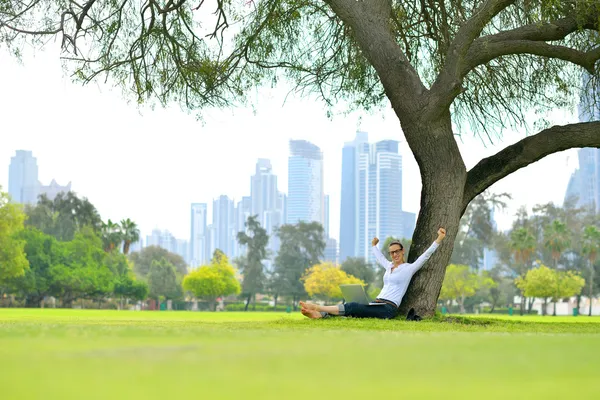 Woman with laptop in park — Stock Photo, Image