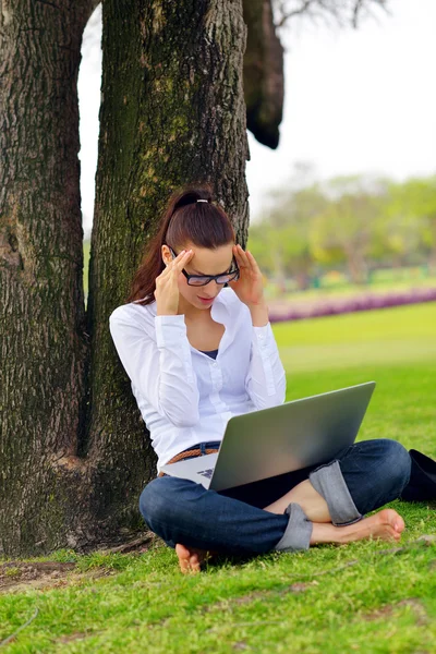 Femme avec ordinateur portable dans le parc — Photo