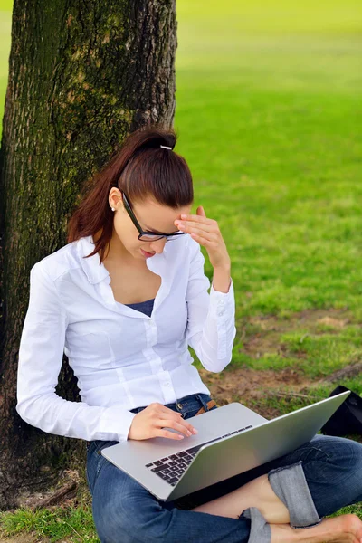 Vrouw met laptop in park — Stockfoto