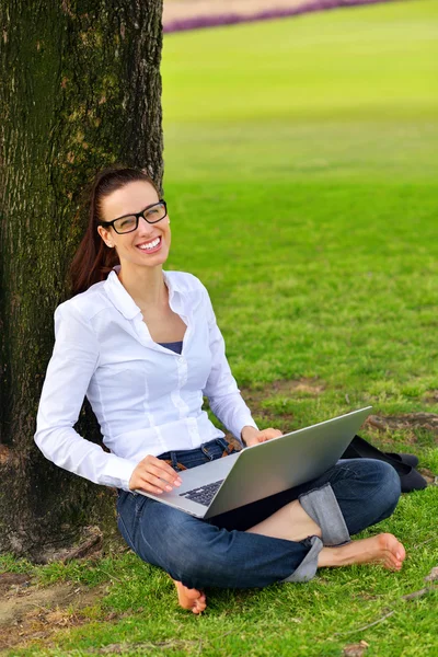 Femme avec ordinateur portable dans le parc — Photo