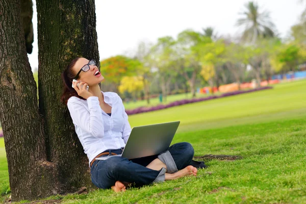 Femme avec ordinateur portable dans le parc — Photo