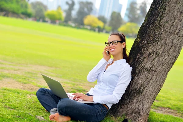 Femme avec ordinateur portable dans le parc — Photo