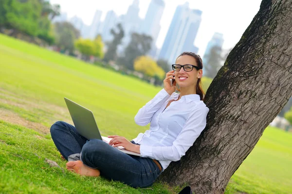 Žena s laptopem v parku — Stock fotografie