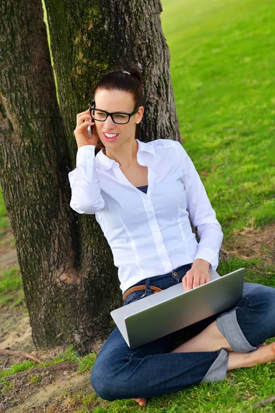 Femme avec ordinateur portable dans le parc — Photo