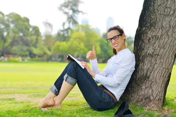 Young woman reading a book in the park — Stock Photo, Image