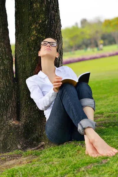 Молодая женщина читает книгу в парке — стоковое фото