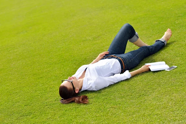 Giovane donna che legge un libro nel parco — Foto Stock