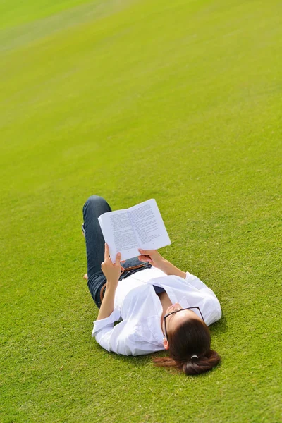 Jonge vrouw leest een boek in het park — Stockfoto