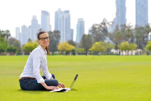 Femme avec ordinateur portable dans le parc — Photo