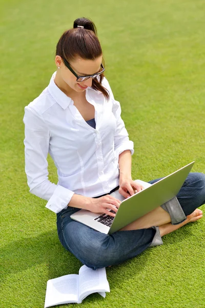 Femme avec ordinateur portable dans le parc — Photo