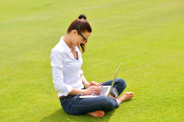 Femme avec ordinateur portable dans le parc — Photo