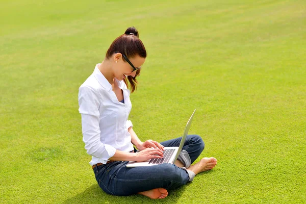 Femme avec ordinateur portable dans le parc — Photo