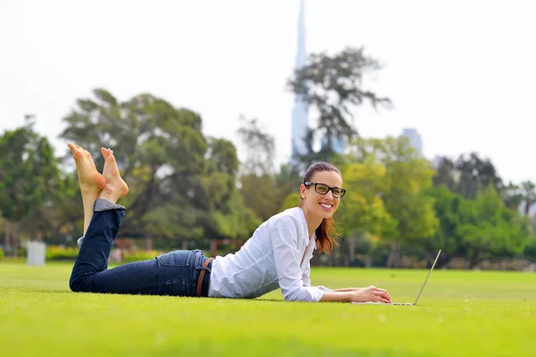 Žena s laptopem v parku — Stock fotografie