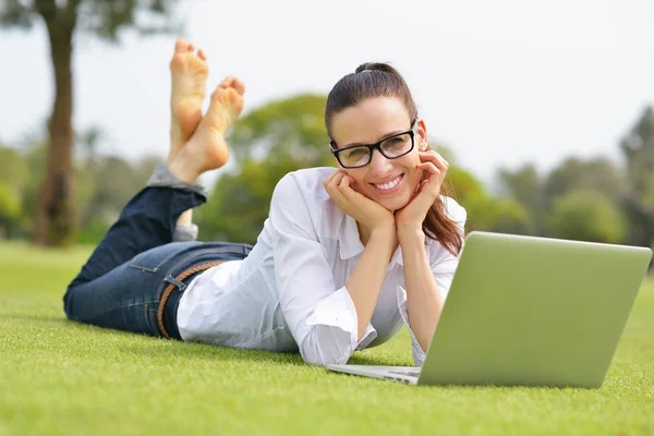 Vrouw met laptop in park — Stockfoto