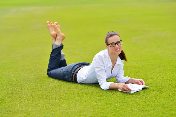 공원에서 책을 읽고 있는 젊은 여자 — 스톡 사진
