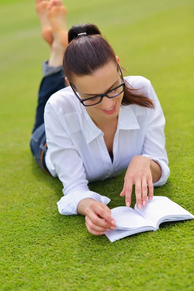 Genç bir kadın parkta kitap okuyor. — Stok fotoğraf