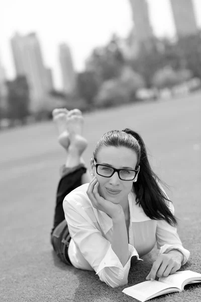 Young woman reading a book in the park — Stock Photo, Image