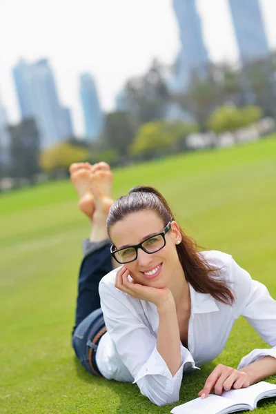 Jonge vrouw leest een boek in het park — Stockfoto