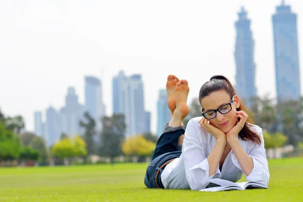 Giovane donna che legge un libro nel parco — Foto Stock