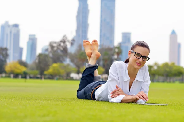 Bella giovane donna con tablet nel parco — Foto Stock