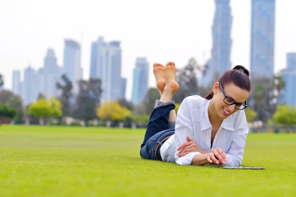 Bella giovane donna con tablet nel parco — Foto Stock