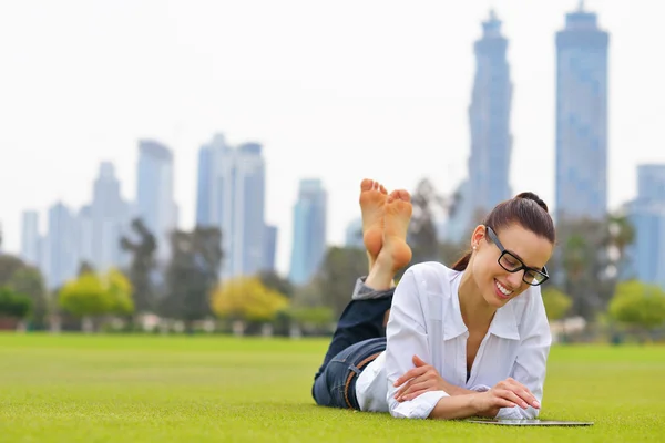 Bella giovane donna con tablet nel parco — Foto Stock