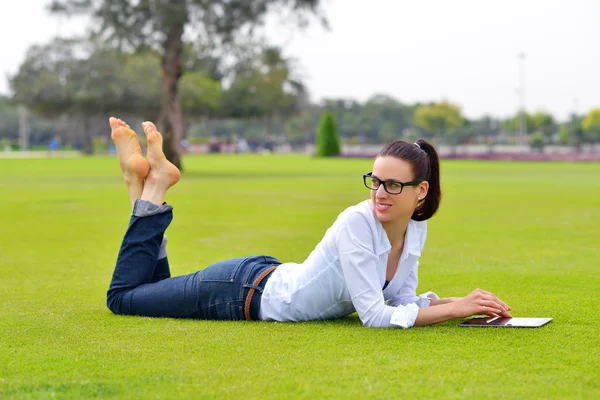 Beautiful young woman with tablet in park — Stock Photo, Image