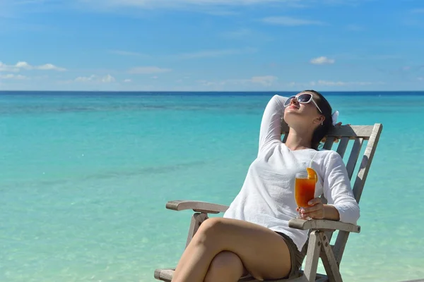 Schöne junge Frau mit einem Drink am Meer — Stockfoto