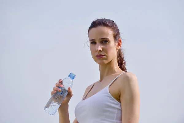 Young beautiful woman drinking water after fitness exercise — ストック写真