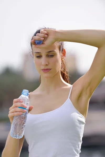 Young beautiful woman drinking water after fitness exercise — ストック写真