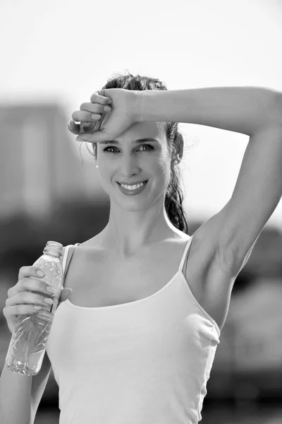 Joven hermosa mujer bebiendo agua después de ejercicio físico — Foto de Stock