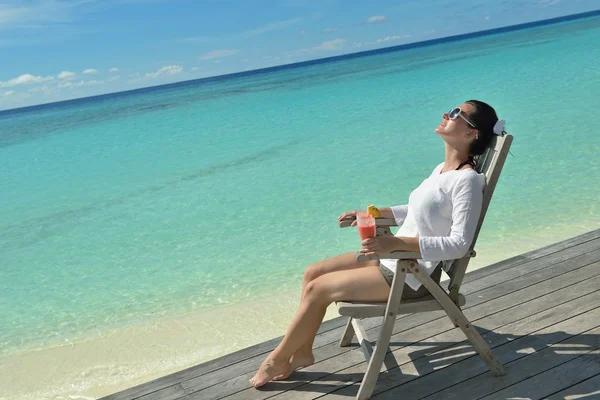 Schöne junge Frau mit einem Drink am Meer — Stockfoto