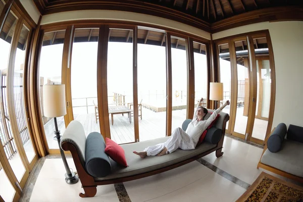 Jovem feliz relaxar em casa no sofá — Fotografia de Stock