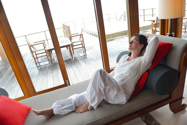 Jovem feliz relaxar em casa no sofá — Fotografia de Stock