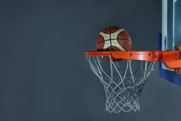 Basketball ball and net on grey background — Stock Photo, Image