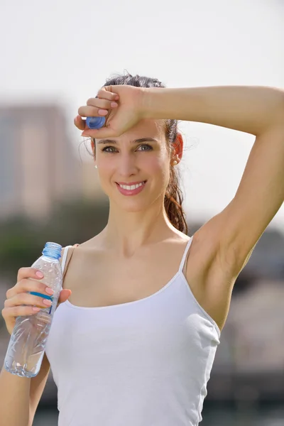 Young beautiful woman drinking water after fitness exercise — ストック写真