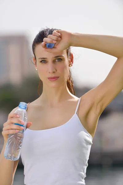 Joven hermosa mujer bebiendo agua después de ejercicio físico — Foto de Stock