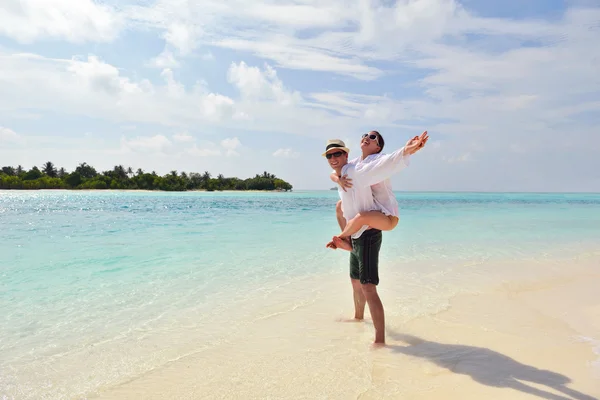 Glückliches junges Paar hat Spaß am Strand — Stockfoto