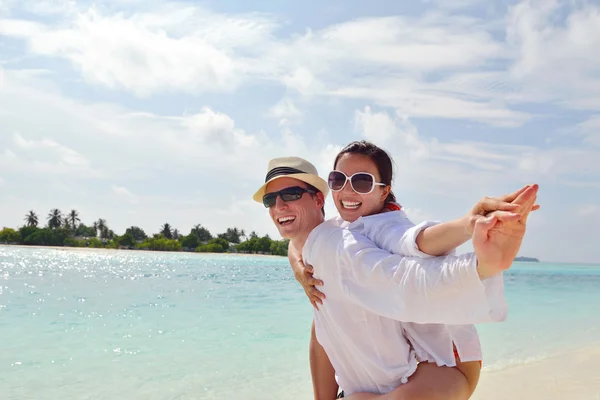 Feliz pareja joven divertirse en la playa — Foto de Stock